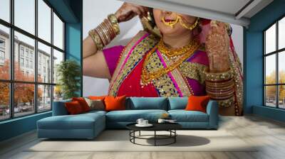 a beautiful Indian girl in bridal dress wearing red saree and gold ornaments Wall mural