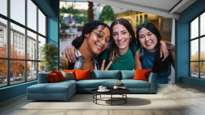 Three college student girls taking a selfie at the university campus during a class break. Wall mural