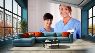 senior and young nurse smiling at you Wall mural