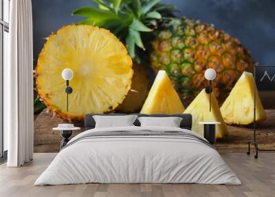 Ripe pineapple fruit cut in half and triangle shape on a rustic wooden table for high fiber fruits concept. Wall mural