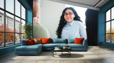 Businesswoman managing her team during session on business strategies, leading in a collaborative office setting Wall mural