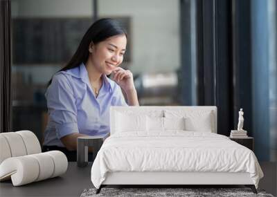 Asian woman working with laptop in her office. business financial concept. Wall mural