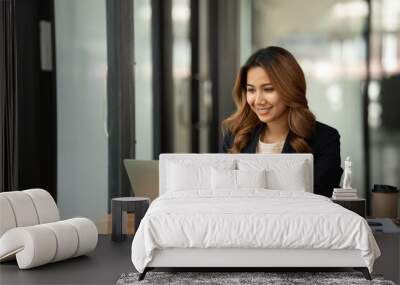 Asian woman working with laptop in her office. business financial concept. Wall mural