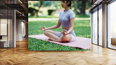 Beautiful young asian woman yoga exercising in the park. Wall mural