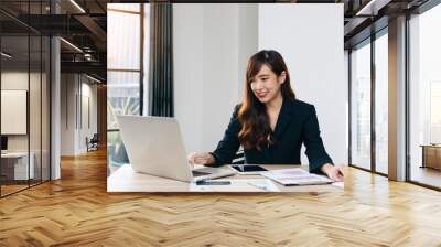 Business women are analyzing and evaluating marketing for a company using graphs on their desks in the office Concept of business risk analysis and assessment Wall mural