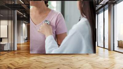 Doctors are using a medical stethoscope to measure the abnormality of the patient being treated for the abnormalities within the hospital. Wall mural