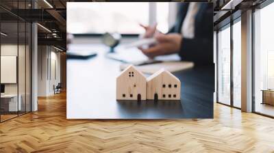 House sales deals with real estate agents with a small house model in the foreground. Wall mural