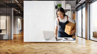 Startup small business entrepreneur of freelance Asian woman using a laptop with box Cheerful success online marketing packaging box and delivery SME idea concept. Wall mural