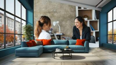 Team work process. Two asian women with laptop in open space office. Business concept. Wall mural