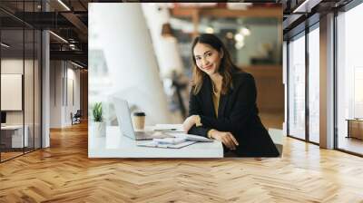 Young asian woman using computer laptop. looking at the camera with showing success. Wall mural