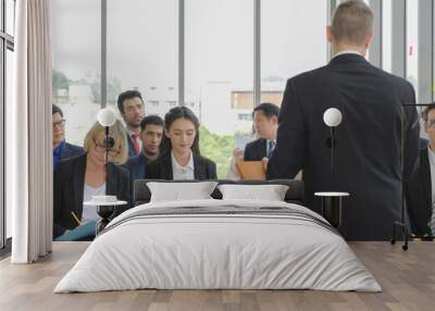 Diversity caucasian business woman taking note while listening speech from speaker with the others in corporate seminar event at conference room. Wall mural