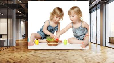 little girls twins sitting on floor, playing with easter eggs Wall mural