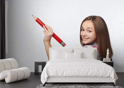 Teen girl writing with big pencil on copy space Wall mural