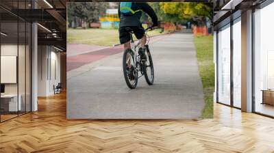 Man riding a bicycle exercising in a city parke outdoors Wall mural