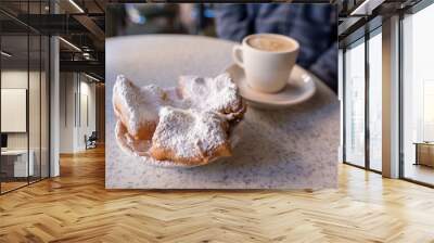 Beignets covered with powdered sugar, served with cafe au lait at the famous Cafe Du Monde in the French Quarter. Shallow focus on the powdered sugar for effect. Wall mural