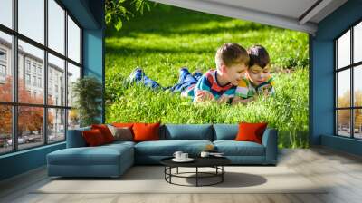 Beautiful happy children, boy brothers, exploring nature with magnifying glass, summertime Wall mural