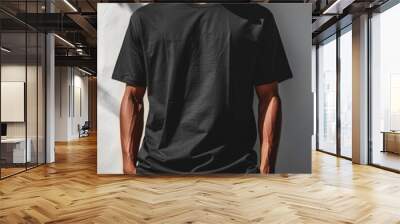 An oversized black tshirt on a minimalist white wall, perfect for graphic design mockups Wall mural