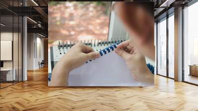 Man making report using comb binding machine - people working with stationary tools concept Wall mural