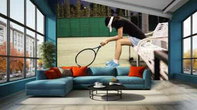 Sad lady tennis player sitting in the court after lose a match - people in sport tennis game concept Wall mural