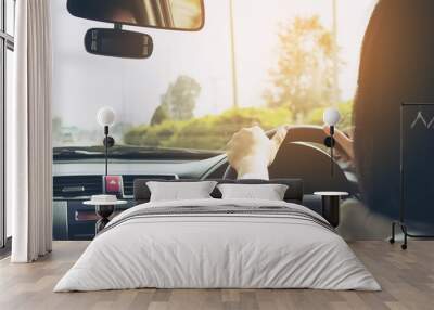 Woman driving car using two hand Wall mural