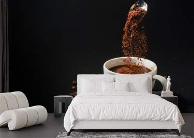 pouring coffee powder on coffee cup on dark background Wall mural