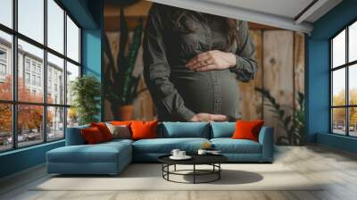 a pregnant woman is holding her belly Wall mural