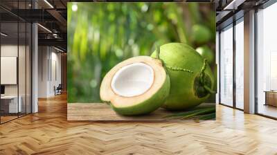 Coconut juice in half fruit with coconut tree background. Wall mural