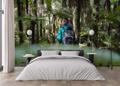 Brunette woman exploring the wild forest with her camera Wall mural