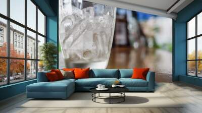 Glass with ice on table Wall mural