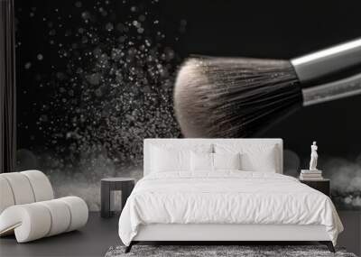 A makeup brush dispersing powder against a dark background. Cosmetic tools for beauty and fashion applications. Wall mural