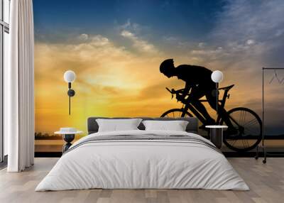 silhouette of man ride a bicycle in sunset background Wall mural