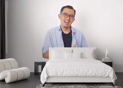 Portrait of happy Asian man in blue shirt on isolated white background. Wall mural