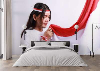 Portrait of young asian woman with scarf kissing red and white flag of indonesia Wall mural