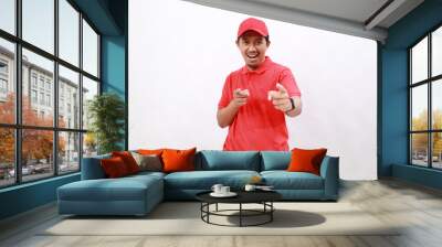 Professional happy delivery employee man wear red cap t-shirt uniform workwear work as dealer courier point index finger camera on you isolated on white background. Service concept Wall mural