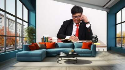 Young asian Businessman in office working while talking on the phone. isolated on white Wall mural