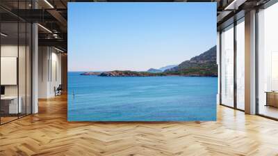 sea Bay fenced rocky shores. calm clear sea. two people floating on SUP boards Wall mural