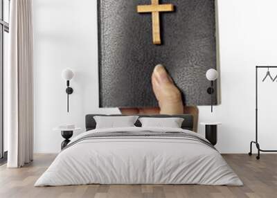 Hand holding a bible with wooden cross Wall mural