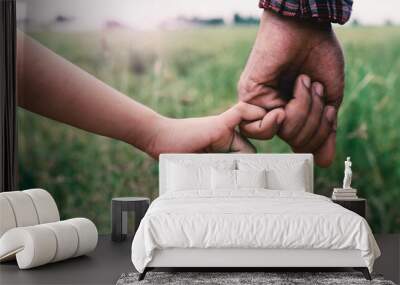 A girl holding hands with father,Vintage filters. Wall mural