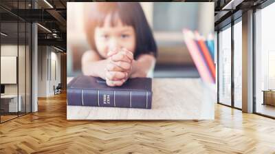 Little Asian girl pray with bible in classroom at school, bible study concept Wall mural