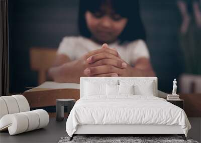 Little girl praying with bible in church Wall mural