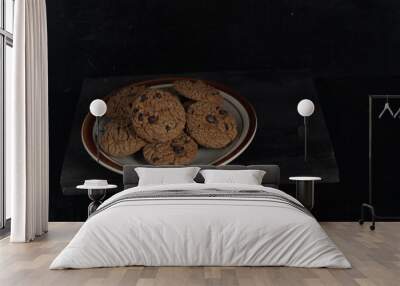 Chocolate chip cookies on plate on black background Wall mural