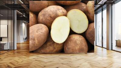 A close up image of several large organic russet potatoes in a pile.  Wall mural