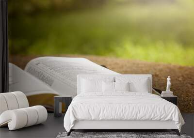 An Opened Bible on a Table in a Green Garden Wall mural