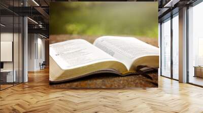 An Opened Bible on a Table in a Green Garden Wall mural