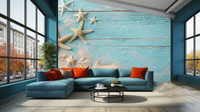 The blue wooden background is decorated with starfish and sand. Top view. Frame for text, congratulations, presentation or advertising banner. Wall mural