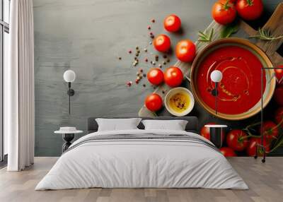 Top view of a rustic wooden table with a bowl of homemade tomato sauce, surrounded by fresh ingredients like basil, garlic, and chili peppers, perfect for a delicious, traditional Italian meal. Wall mural