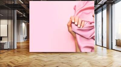 Beautiful woman manicure on creative pink background with silk fabric. Minimalist trend. Wall mural