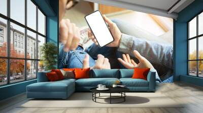 Mockup image blank white screen cell phone.couple hand holding texting using mobile on sofa at home.background empty space for advertise text.people contact marketing business and technology  Wall mural