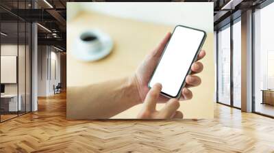 Mockup image blank white screen cell phone.man hand holding texting using mobile on desk at coffee shop.background empty space for advertise text.people contact marketing business,technology  Wall mural