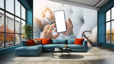 Mockup image blank white screen cell phone.man hand holding texting using mobile on sofa at home.background empty space for advertise text.people contact marketing business,technology Wall mural